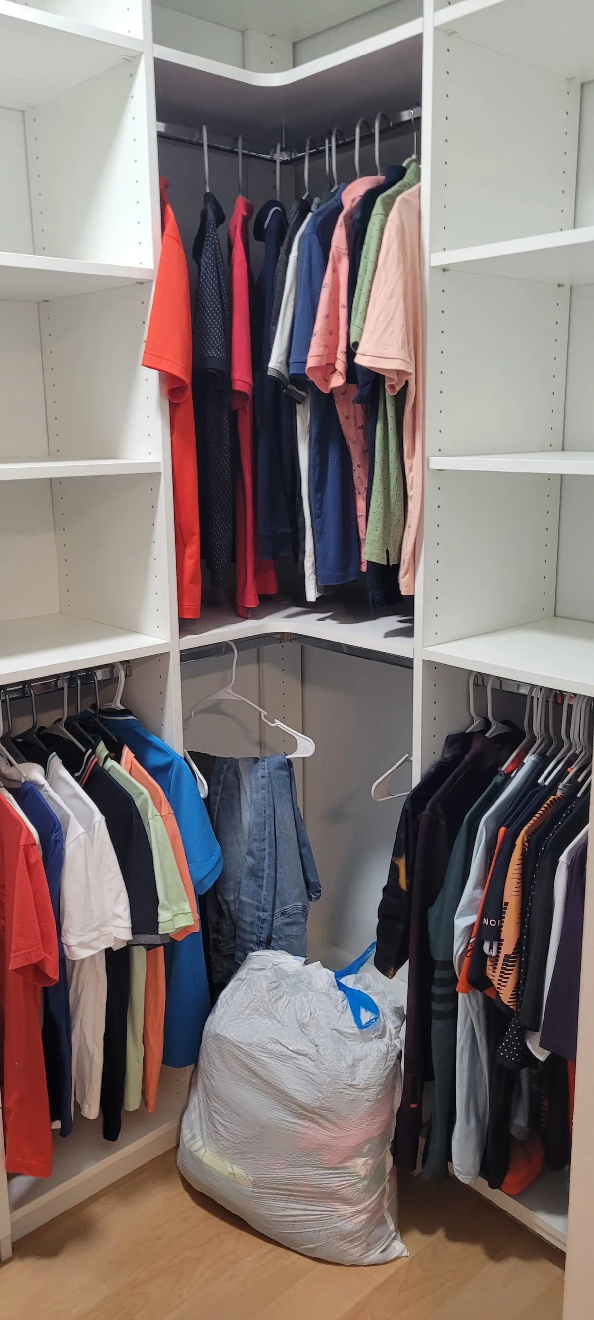Walk-in closet with corner shelving and drawers in use