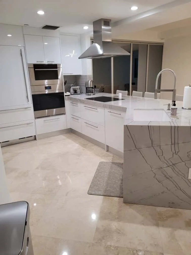 Modern white kitchen with island and stainless hood